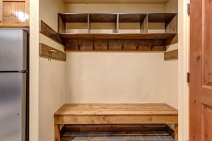 Your own organized mudroom awaits with custom wooden storage cubbies and hooks for your gear.