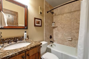 Unwind in your elegant bathroom featuring a luxurious soaking tub with beautiful stone tile surround.