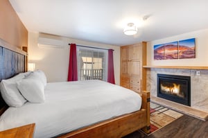 Resort Plaza 5024s main suite with a king size bed and gas burning fireplace.
