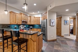 Your fully equipped kitchen features rich wood cabinetry, granite countertops, and modern stainless steel appliances  perfect for preparing meals during your stay.
