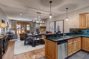 Your openconcept kitchen features granite countertops, stainless steel appliances, and warm wood cabinetry, flowing seamlessly into the living area with cozy fireplace.