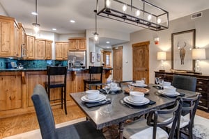 Your beautifully appointed kitchen and dining area features warm wood cabinetry, elegant granite counters, and a stylish dining table perfectly set for memorable meals together.