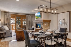 Gather around your elegant dining table while enjoying the warmth of your stone fireplace and mountain views through floortoceiling windows.