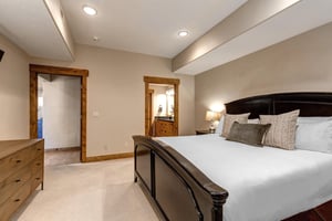 Unwind in your beautifully appointed bedroom featuring plush bedding, warm wood accents, and stylish furnishings designed for your comfort and relaxation.