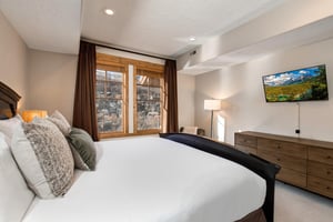 Sink into your comfortable bed and unwind while watching the wallmounted TV. Natural light streams through the woodenframed windows, creating a cozy mountain retreat atmosphere.