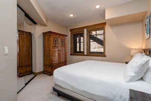 Sink into plush bedding surrounded by warm wood furnishings and natural light  your perfect retreat after mountain adventures.