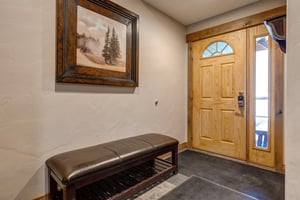 Step into your welcoming entryway where mountain artwork and a comfortable bench create the perfect spot to settle in after your adventures.