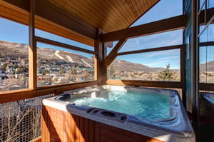Soak in your private hot tub while enjoying sweeping mountain and valley views through floortoceiling windows in this stunning covered outdoor spa area.