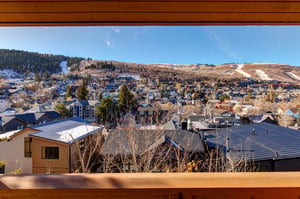 Panoramic mountain town view showcasing the surrounding ski resort community and snowcapped peaks in the distance.