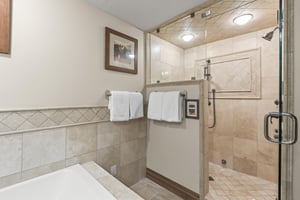 Unwind in your spalike bathroom featuring a spacious walkin shower with rainfall fixtures and elegant tile work.