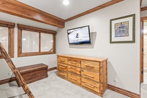 Your cozy retreat features rustic wood furnishings and a mounted TV for relaxing after mountain adventures.