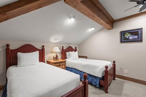 Cozy twin beds await under rustic exposed beams, with your own wallmounted TV for evening entertainment.