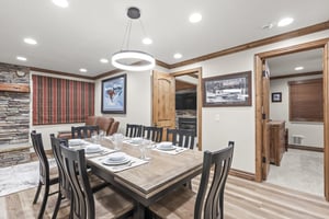 Gather around your spacious dining table, featuring rustic stone accents and warm wood details.