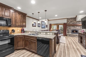 Your spacious kitchen features granite countertops, rich wood cabinets, and a cozy stone fireplace.