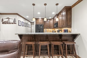 Your mountain getaway features a fully equipped kitchen with wood cabinetry, granite countertops, and a breakfast bar.