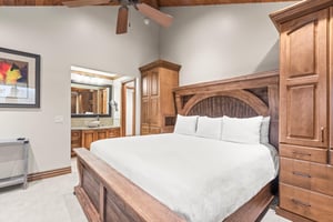 Unwind in your cozy bedroom featuring wood furnishings, crisp white linens, and wood beams overhead.