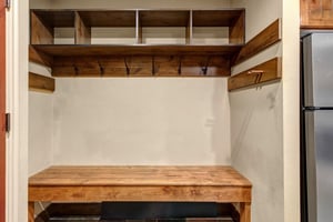 Your personal mudroom features rustic wood shelving, hooks for gear, and a convenient bench for easy transitions.