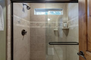 The en suite bathroom offers a walkin shower with sliding glass doors.