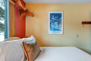 The second bedroom has warm colored walls with artistic touches.