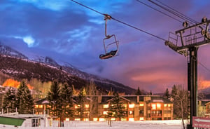 Park City Mountain Resort at twilight with snowy mountains and warm evening lights of Snow Flower Condos.
