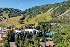 Snow Flower Condominiums nestled in a scenic alpine valley with lush green slopes in summer.