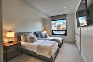 Guest bedroom, platform extra long twin beds, white linens with cozy throw pillows and extra blankets, beautiful plaza views from the large window