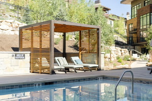 Poolside relaxation, three lounge chairs in the shade structure alongside the Lift Condominium pool.