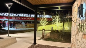 Evening at the Lift Condominiums with the illuminated Sunrise Gondola station just outside the front door for easy ski access.