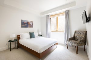 2nd guest bedroom with queen bed with wall mounted flat screen TV
