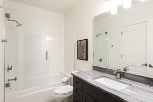 Full bathroom with step in shower and tub with tempered glass enclosure
