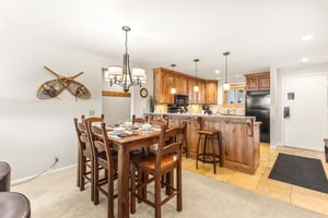 Snow Flower Condominium 14s dining area next to open concept kitchen with additional counter seating.