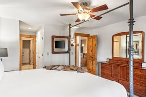 Snow Flower Condominium 14s main suite with private bathroom entrance and dresser.