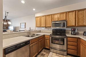 Snow Flower Condominium 147s open concept kitchen with stainless steel appliances.