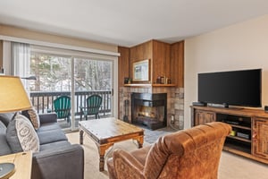 Snow Flower Condominium 147s living room with fireplace and flat screen TV.