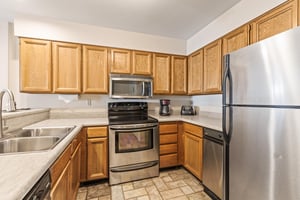 Snow Flower Condominium 147s open concept kitchen with stainless steel appliances.