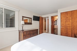 Snow Flower Condominium 147s main suite with dresser and bathroom entrance.