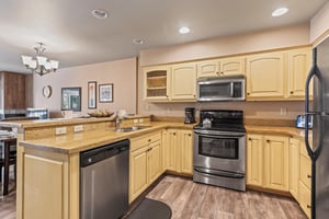 Premier Snow Flower Condominium 107s open concept kitchen with stainless steel appliances.