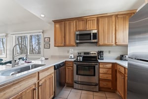 Premier Snow Flower Condominium 130s open concept kitchen with stainless steel appliances.