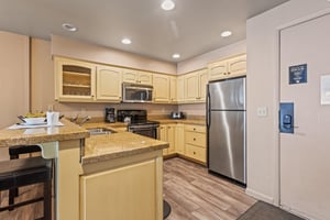 Premier Snow Flower Condominium 107s open concept kitchen with yellow cabinets and breakfast bar..