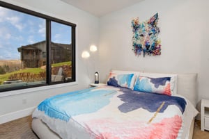 The second bedroom offers a kingsize bed and colorful artwork.
