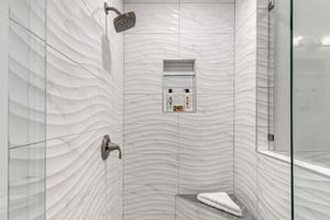 Step into your luxurious walkin shower with stunning wavetextured tiles and rainfall showerhead.