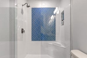 The shared bathroom with walkin shower and glass enclosure.