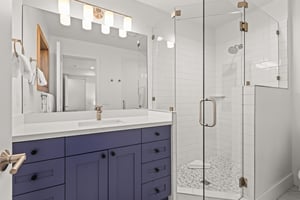 Unwind in your spalike bathroom with a stunning glass shower, elegant vanity, and warm lighting for your morning routine.