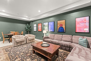 Sink into plush sectional seating surrounded by vibrant film festival posters and warm lighting, perfect for movie nights.