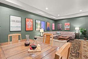 Unwind in your openconcept living space, featuring sage walls with curated artwork and a cozy sectional sofa.