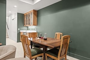 Your elegant dining space features warm wood furnishings against sophisticated sage walls.