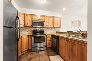 Snow Flower 149 offers a fully equipped kitchen with wood cabinets, granite countertops, and stainless steel appliances.