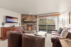 Unwind by the cozy fireplace while enjoying forest views from your living room in this cozy vacation rental.