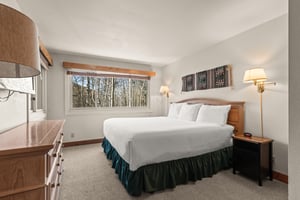 Sink into crisp linens and wake to peaceful forest views from your cozy main suite.