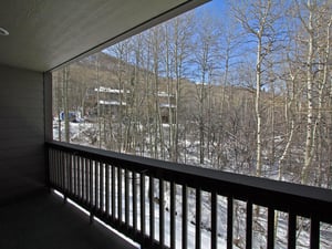 Enjoy the private patio with forest views in the winter at the Snow Flower 149 vacation rental.